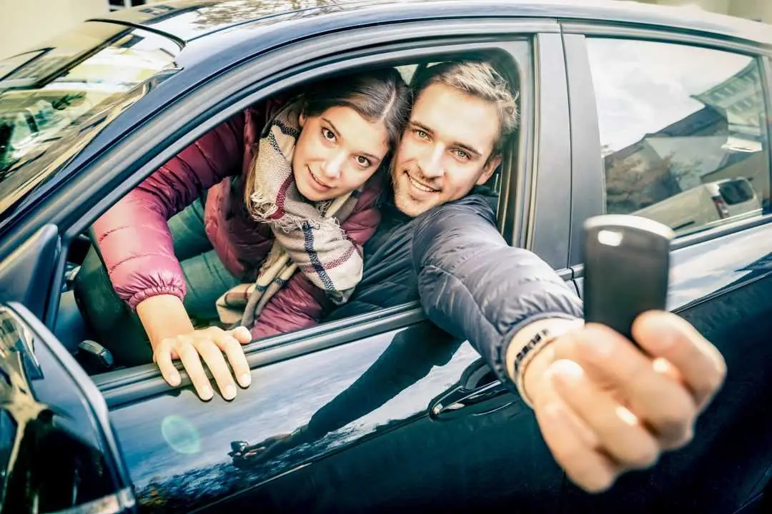 Harga Sewa Mobil Lampung Ke Jakarta, Berapa Biayanya? Happy Couple At Car Rent Showing Electronic Key Ready For The Next Road Trip